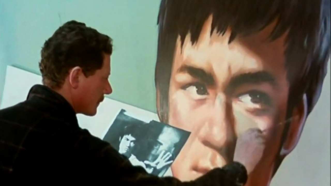 a man painting a mural of a man's face